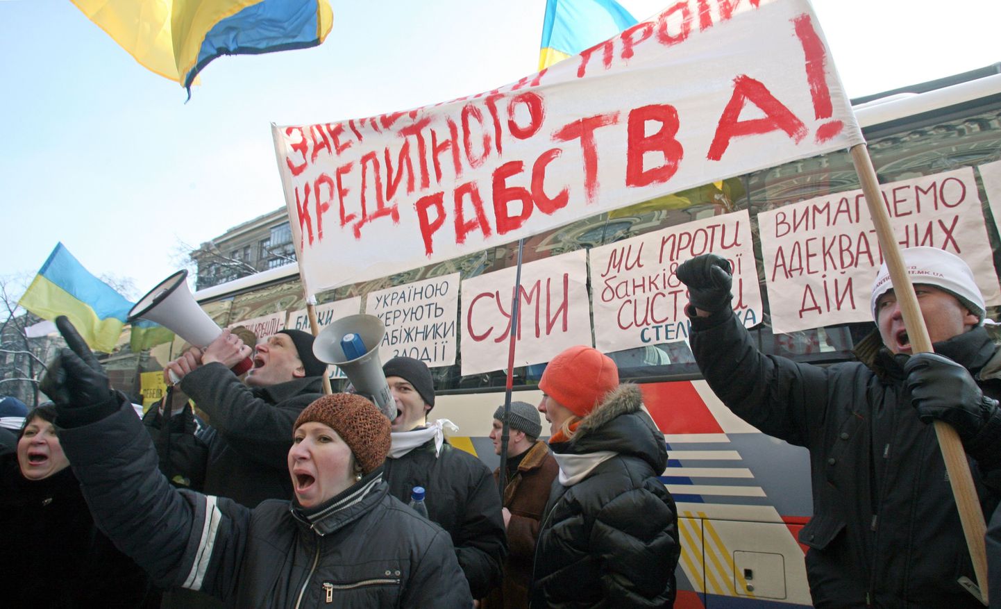 Ukraina hoiustajad protesteerivad riigipanga ees karmistunud raha väljamakse tingimuste vastu. Loosungil on tekst «Hoiustajad on krediidiorjuse vastu».
