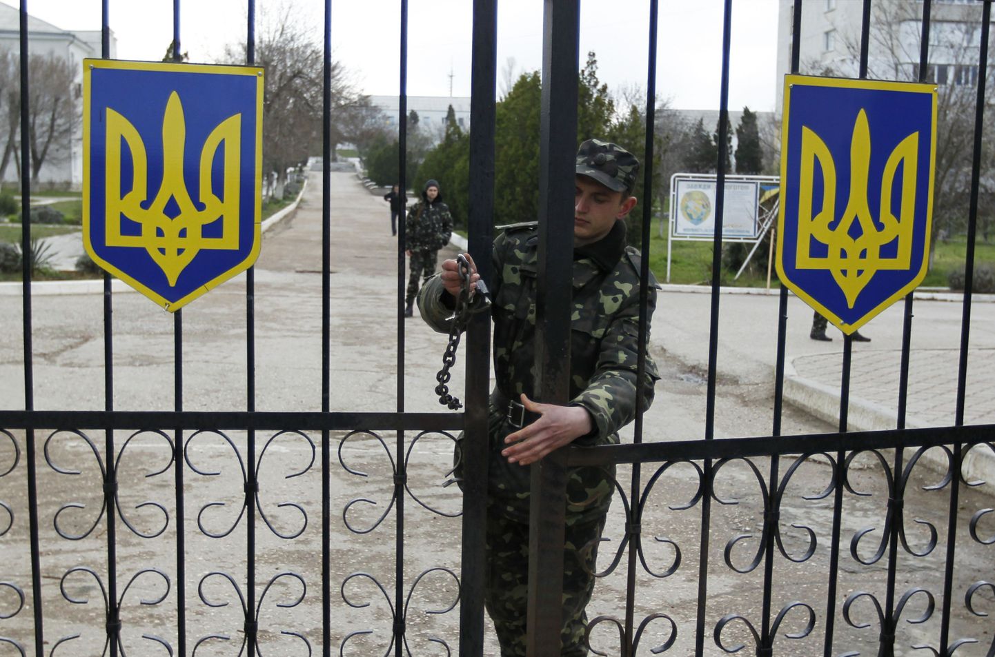 Ukraina sõdur sulgeb Krimmis Belbeki õhuväebaasi väravatt.