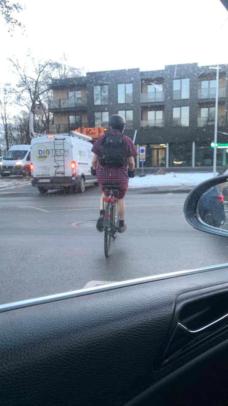 Jalgrattaga sõitev suvises riietuses mees.