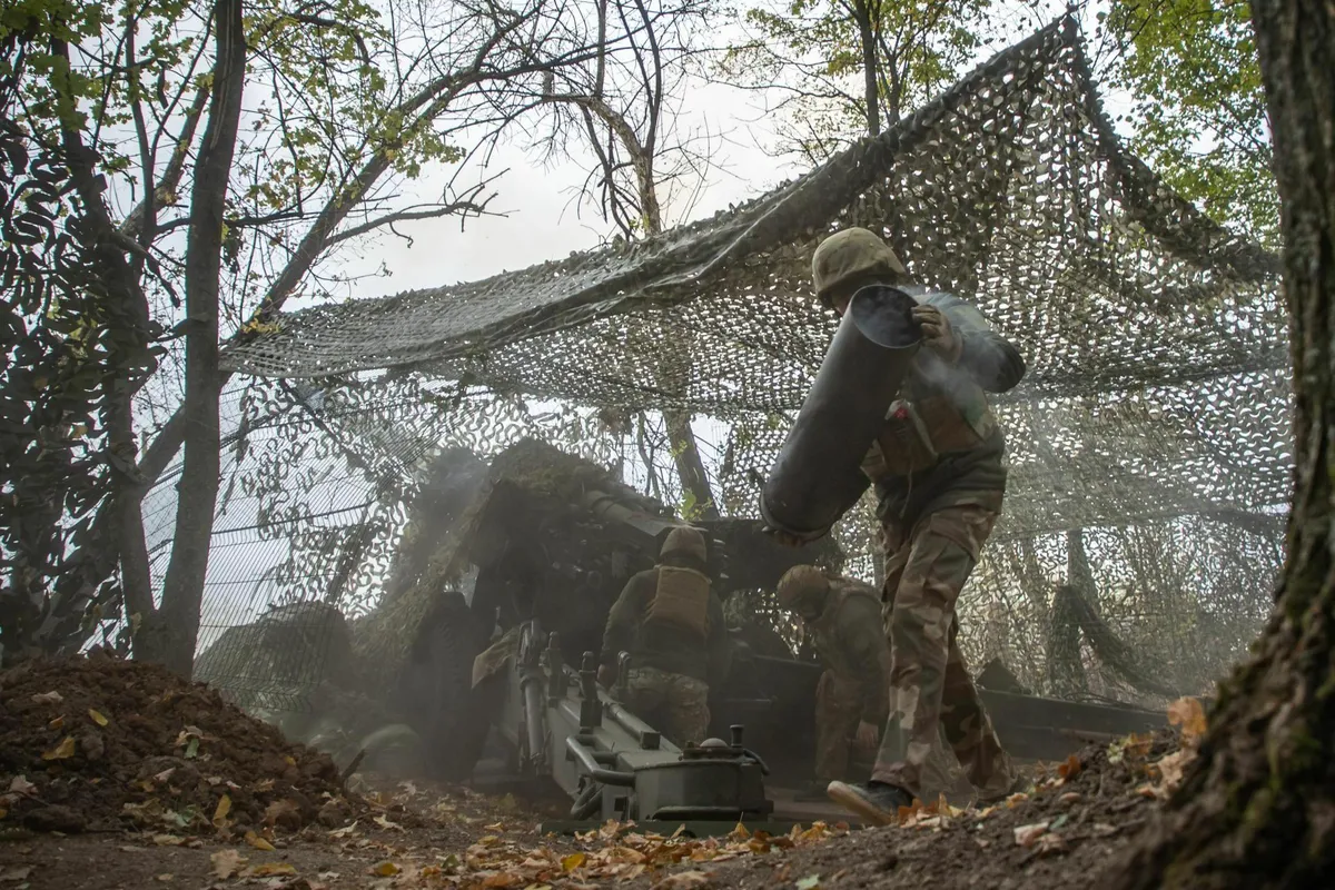An artilleryman from the 13th Brigade of Ukraine's National Guard, known as the Hartia Brigade, removes a shell casing after firing from a Soviet-era Giatsint towed howitzer with a 152-mm caliber.