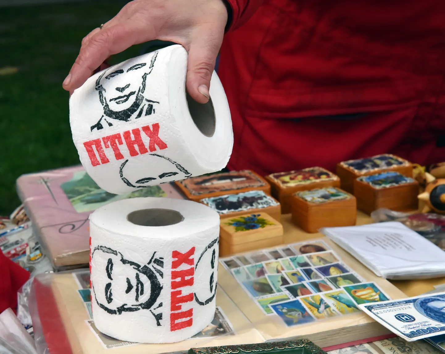 Tänavakaubitseja tutvustab Kiievis enimpopulaarset müügiartiklit ehk wc-paberit, kus on Vene presidenti meenutav pilt.