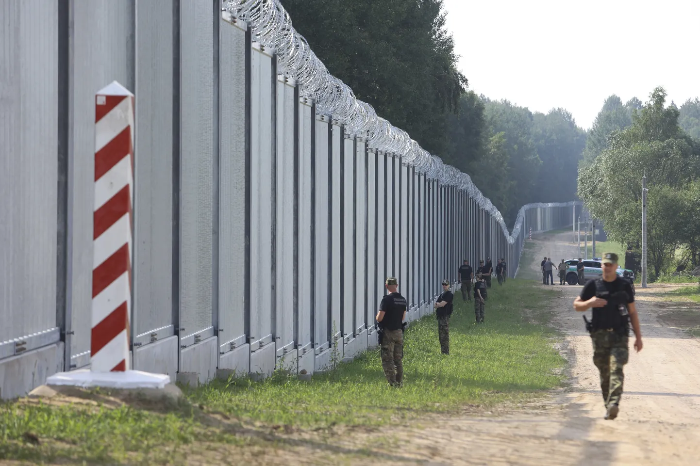 Польские пограничники у стены, возведенной на белорусской границе. 30 июня 2022 г.