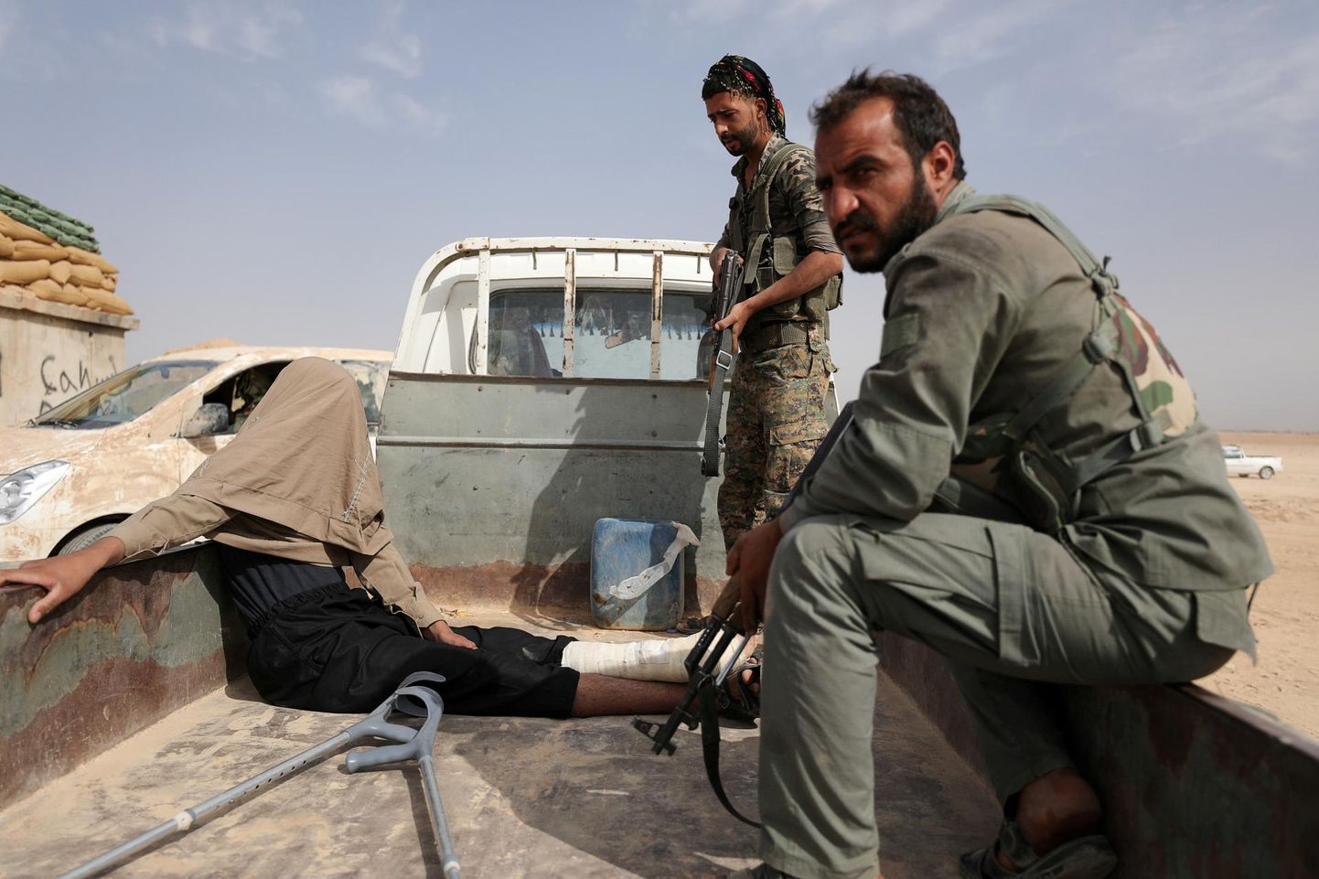 Süüria Demokraatlike Jõudude võitlejad vahi alla võetud mehega, keda kahtlustatakse ISISesse kuulumises. FOTO: Rodi Said/reuters/scanpix