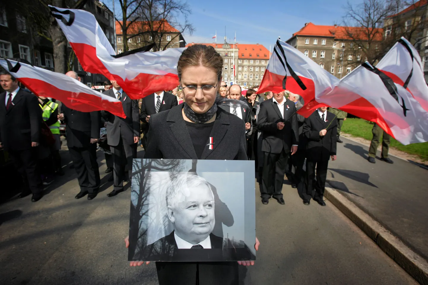Женщина держит портрет Леха Качинского на церемонии поминовения жертв авиакатастрофы.