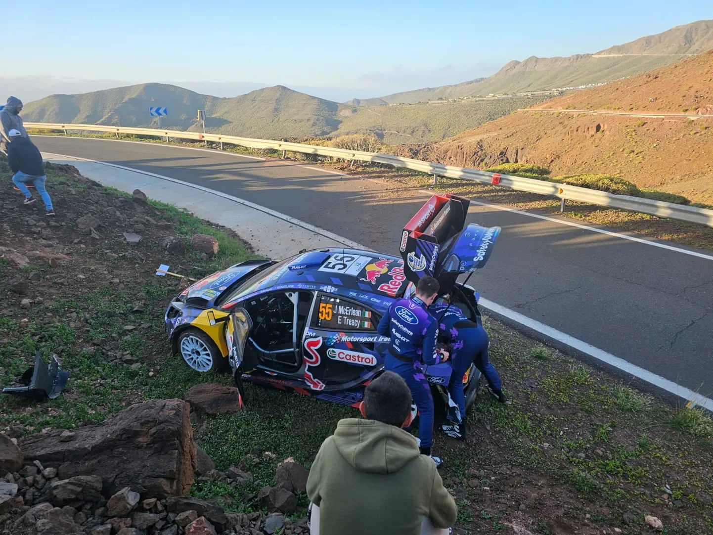 Josh McErlean pärast avariid oma Ford Puma Rally1-auto kallal askeldamas.