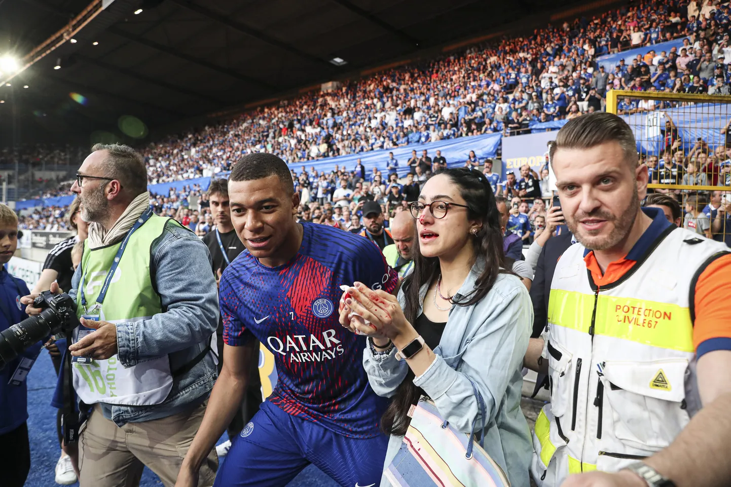 Kylian Mbappe (vasakult teine) koos fänniga, kelle nina ta kogemata palliga veriseks lõi