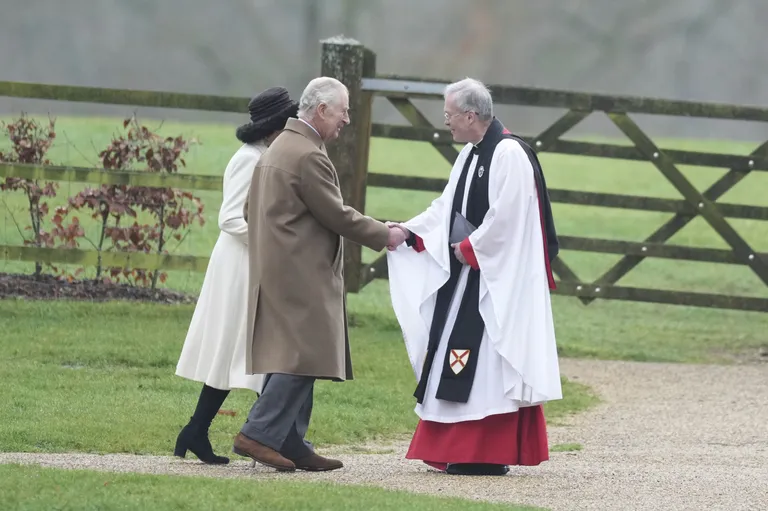 Kuningas Charles III ja kuninganna Camilla kirikuõpetajat tervitamas.