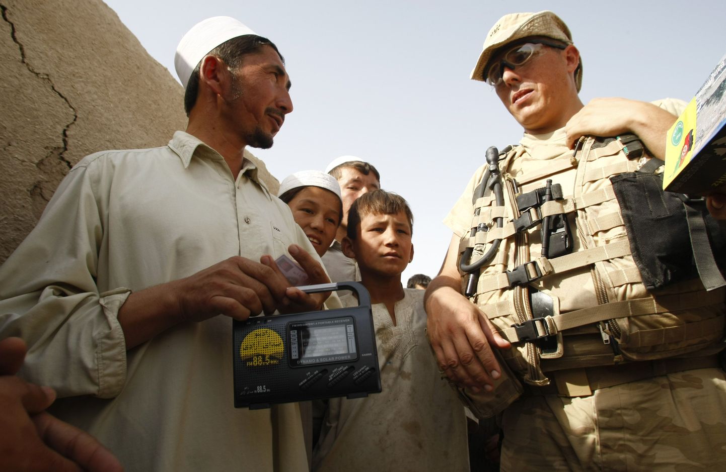 Belgia sõdur ja raadioaparaadi saanud kohalik elanik Afganistanis.