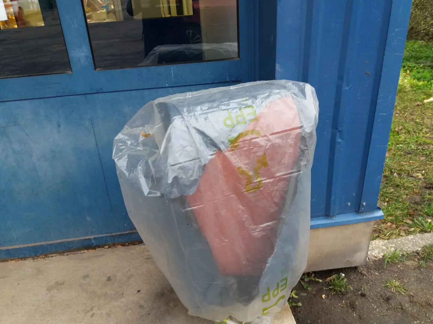 Koristaja hakkas tööpäeva lõppedes prügimahutit kilega katma.