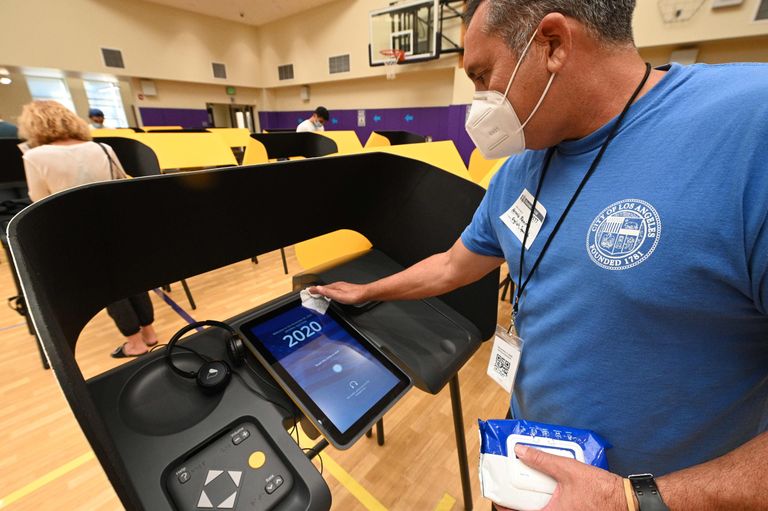 Valimisjaoskonna töötaja puhastab hääletusmasina ekraani kasutajate vahel Beverly Hillsis, Californias. 