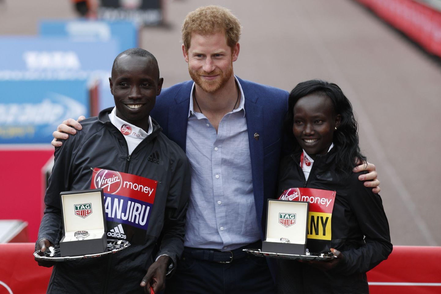 Daniel Wanjiru (vasakul) koos naiste arvestuse võitja Mary Keitany (paremal) ja prints Harryga 2017. aasta Londoni maratoni finišis.