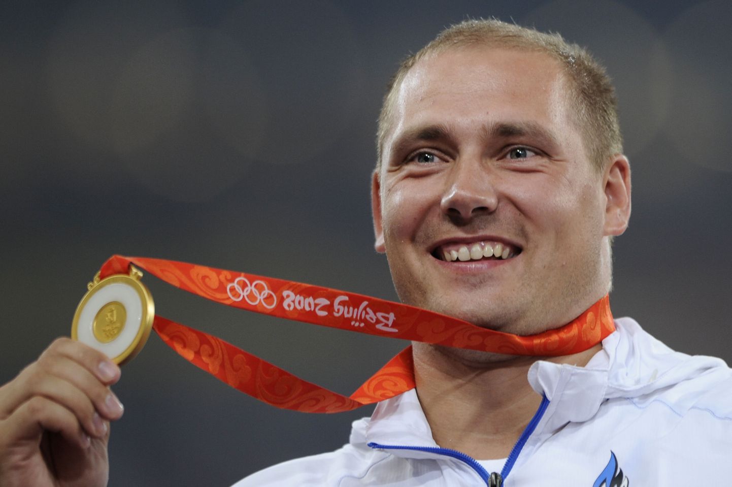 Gerd Kanter poseerimas Pekingi olümpialt võidetud kuldmedaliga.