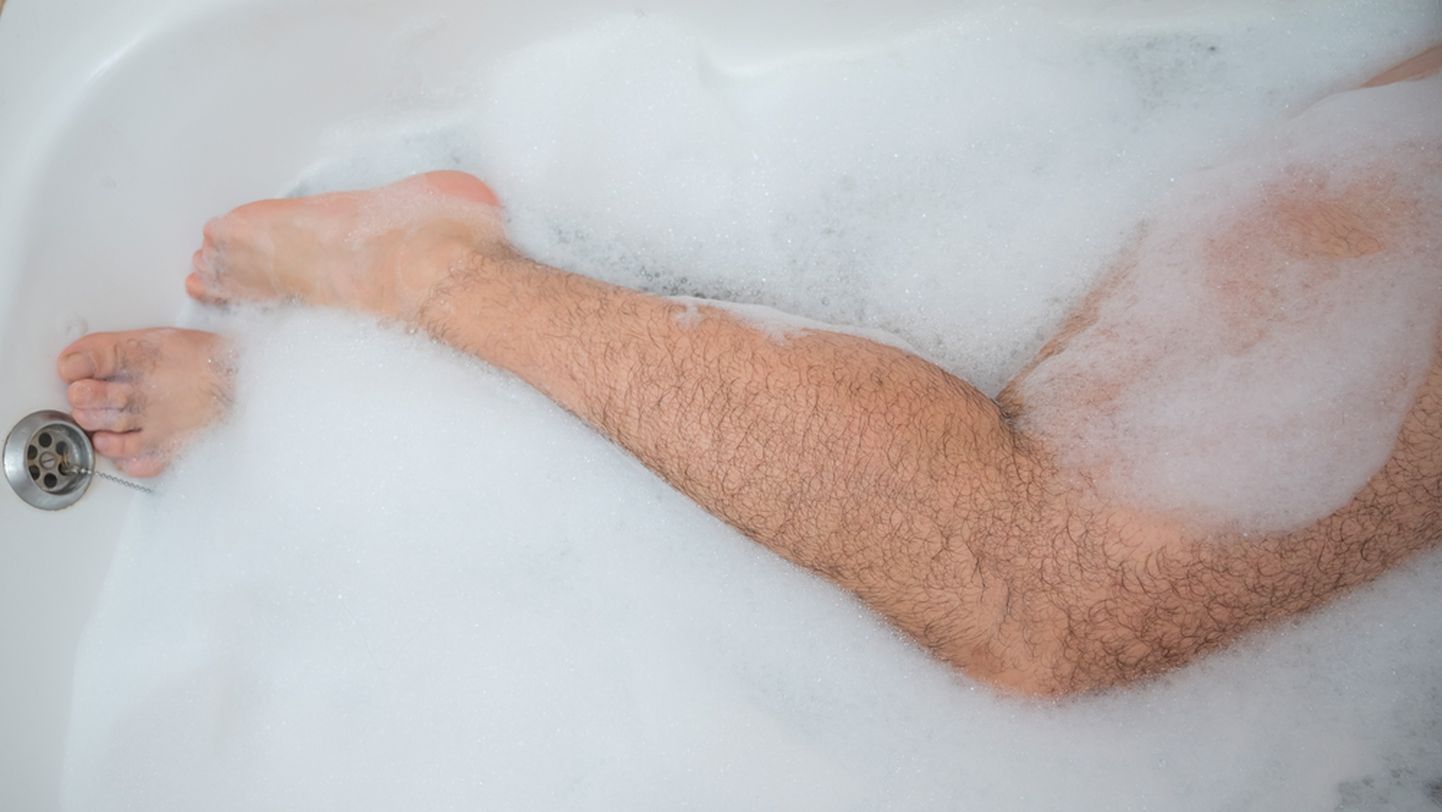 Мужчинна в ванне, снимок иллюстративный