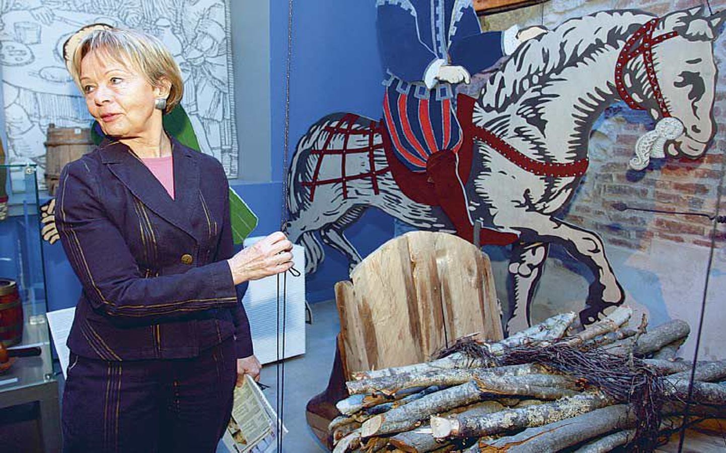 Linnamuuseumi direktriss Maruta Varrak näitab, kuidas külastaja võib nöörist tõmmates panna keskaegsed kujud liikuma.