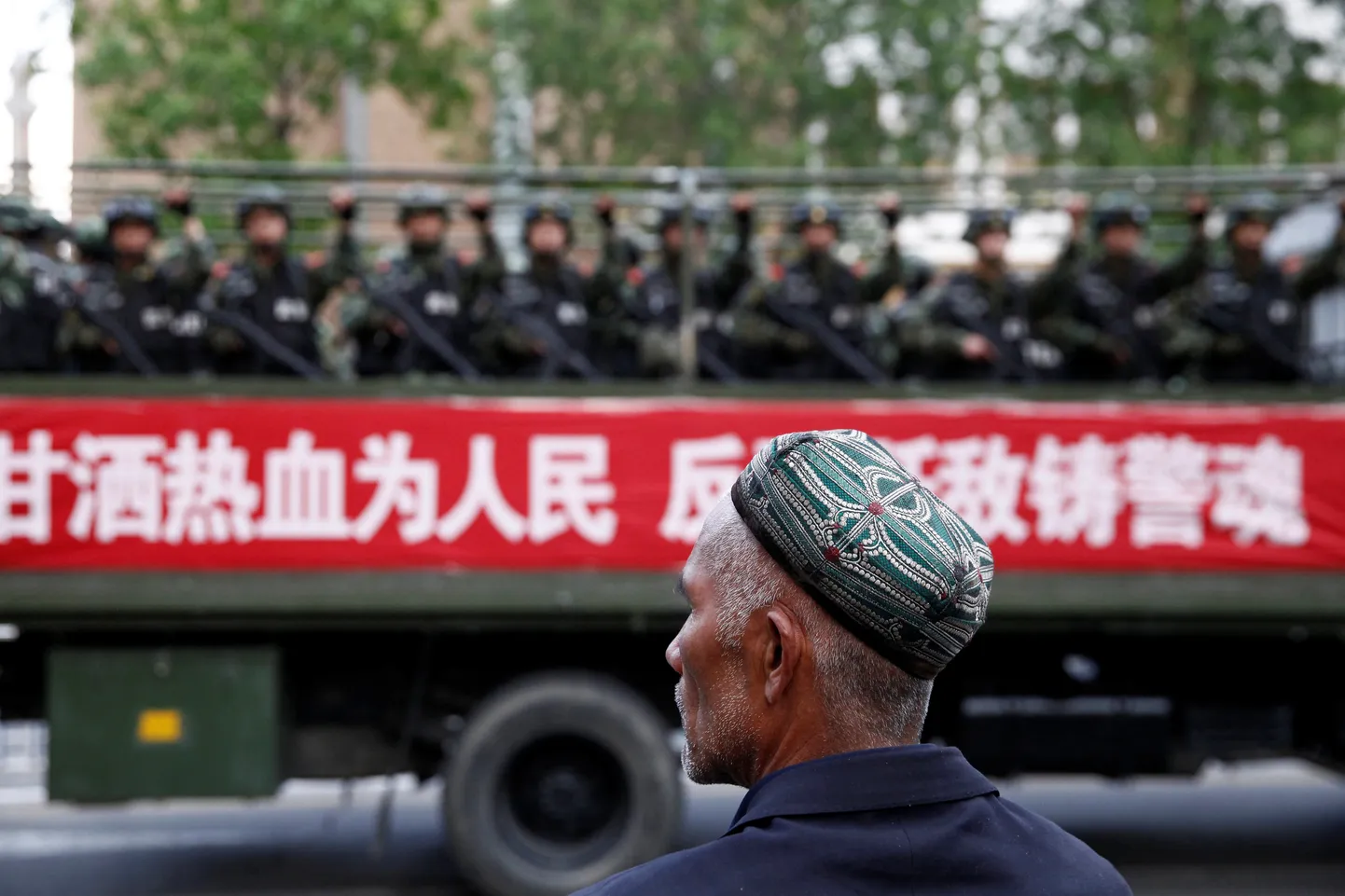 Uiguuri vanamees jälgib Hiina paramilitaarse üksuse möödumist.