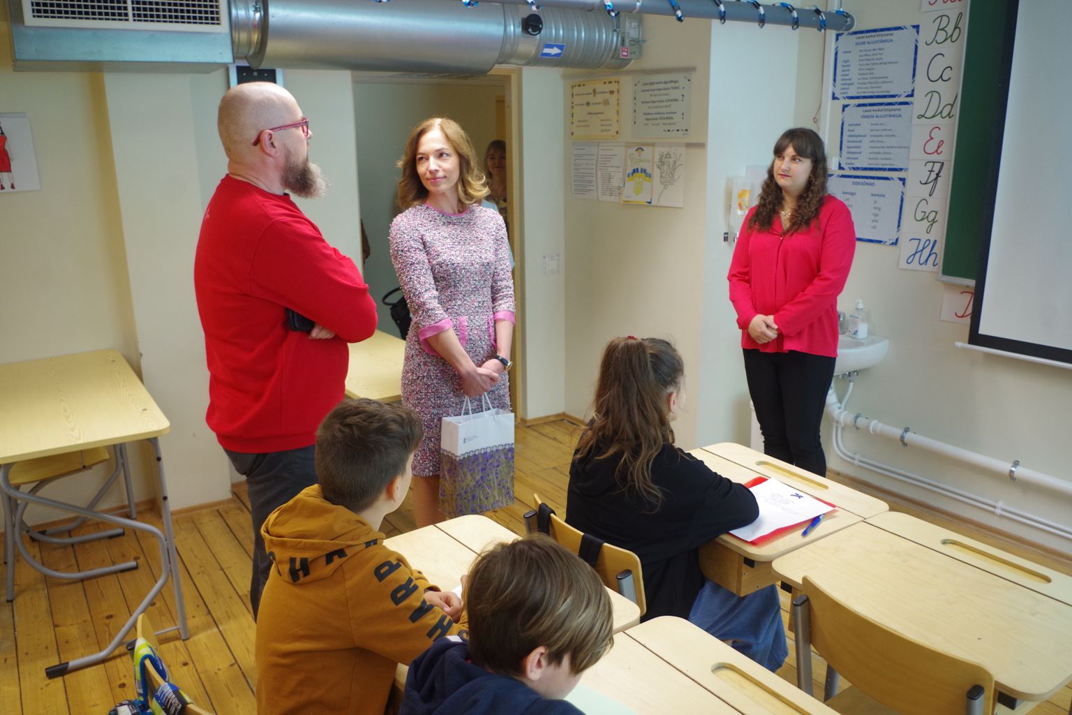 Võru Kreutzwaldi koolis ukrainlaste klassi külastanud haridus- ja teadusminister Liina Kersna (keskel) sõnul saavad ukrainlased sügisest individuaalse õppekava, kuid õpe peab käima eesti keeles.