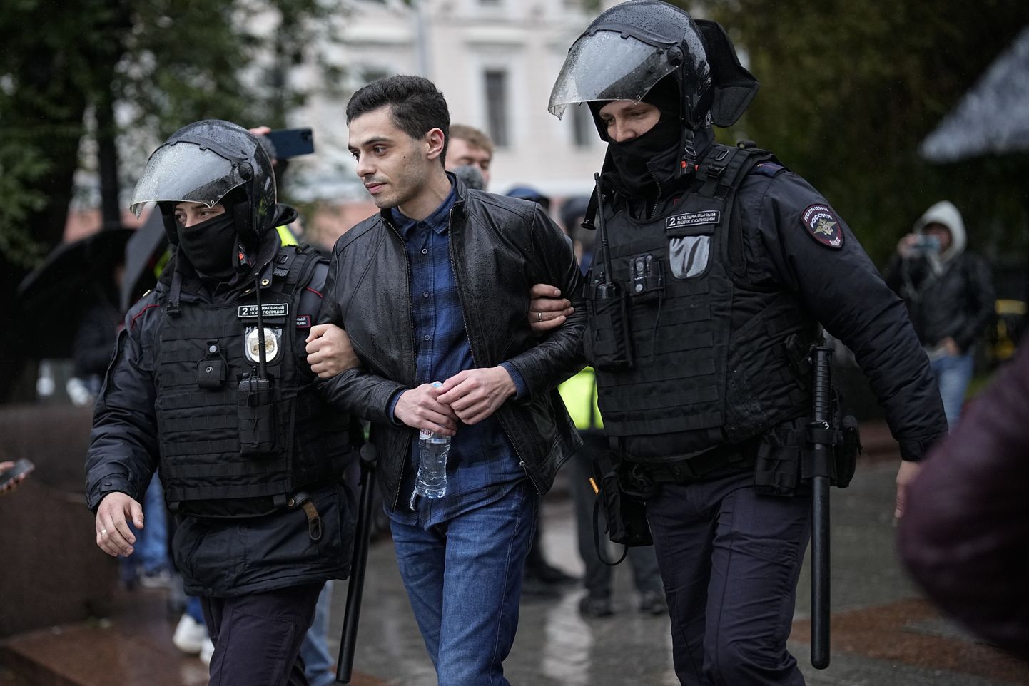Krievijas policisti aiztur vīrieti protestā pret mobilizāciju.