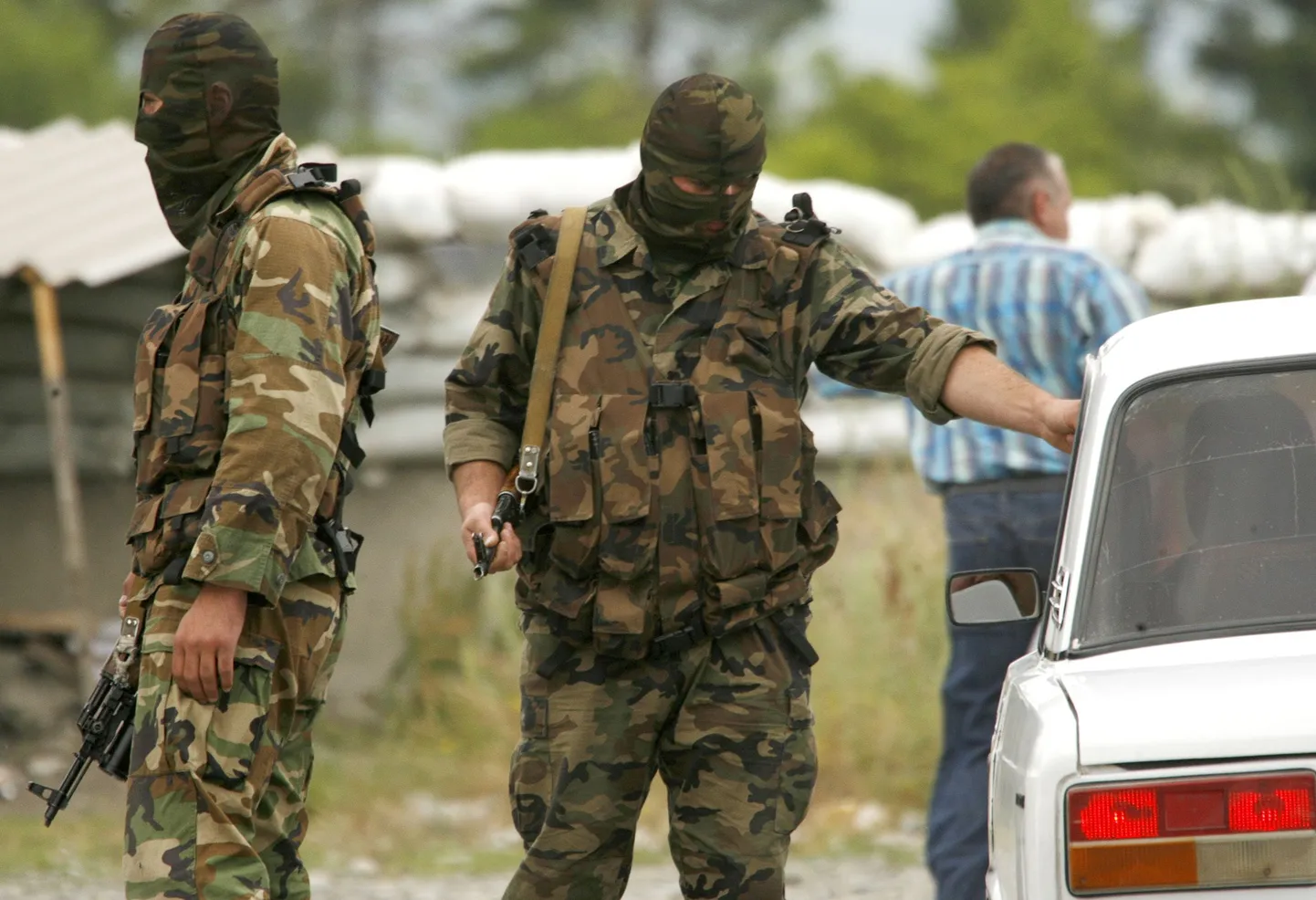 Gruusia politseinikud Lõuna-Osseetia kontrollpunkti juures sõidukit läbi vaatamas.