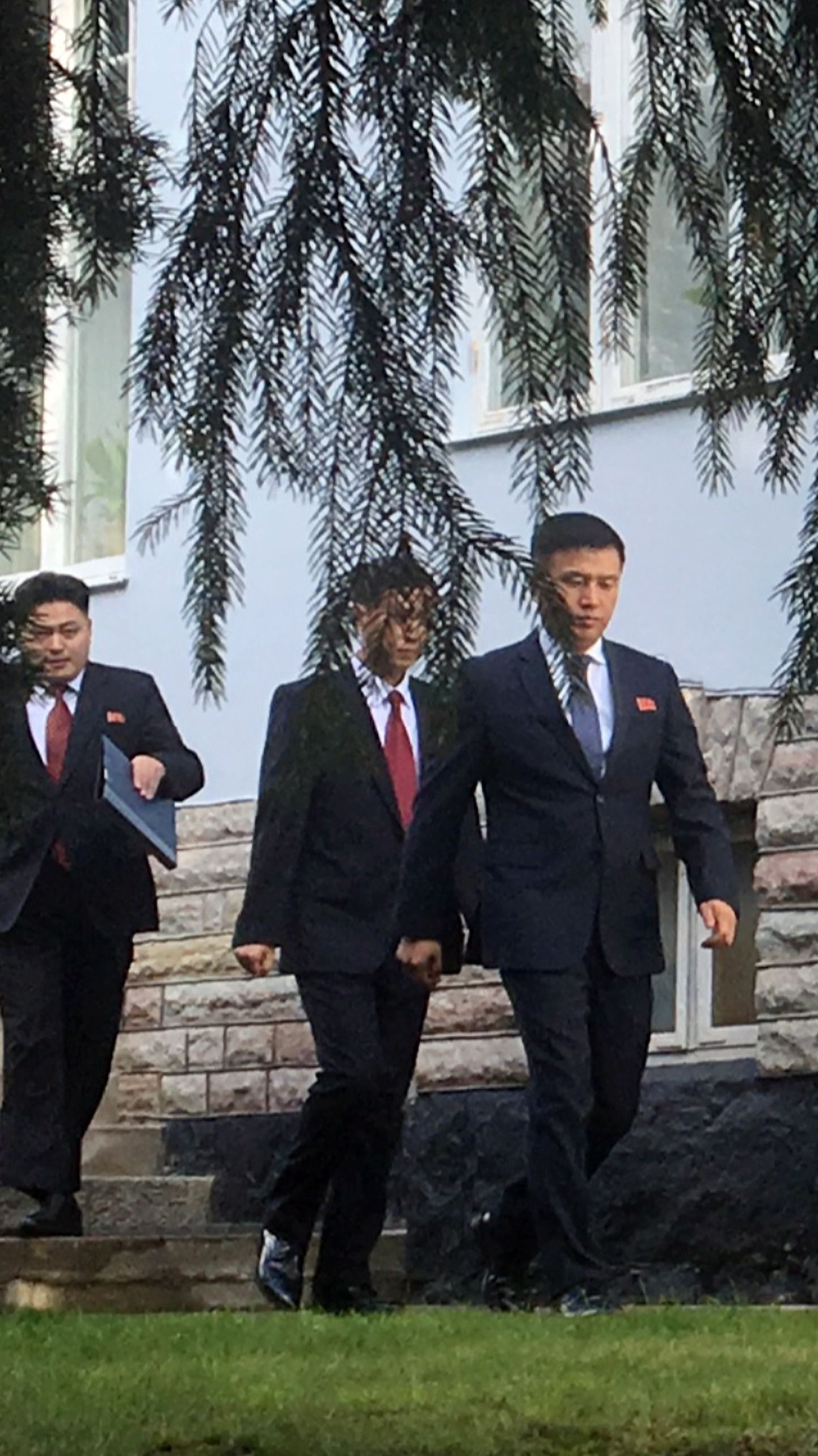 Põhja-Korea delegatsiooni liikmed lahkumas Stockholmi saatkonnast tuumakõnelustele USA esindajatega.