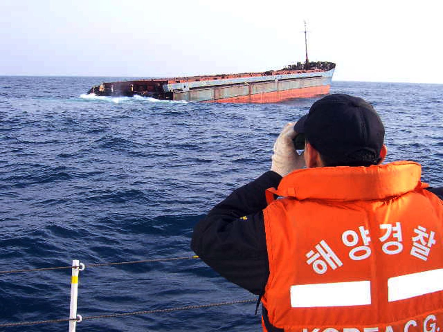 Kambodža lipu all sõitnud kaubalaeva Alexandra nina on veel vee peal. Ümbrust uurib Lõuna-Korea rannavalve esindaja.
