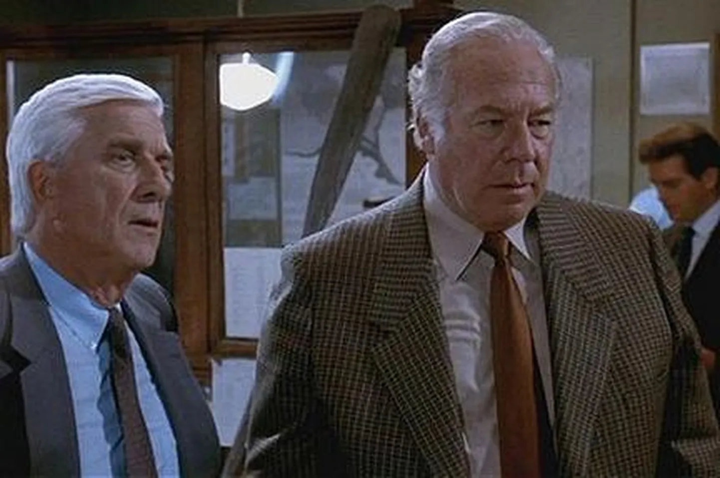 Kaader filmist «Palja relvaga 2 ja pool». pildil Leslie Nielsen ja George Kennedy (paremal)