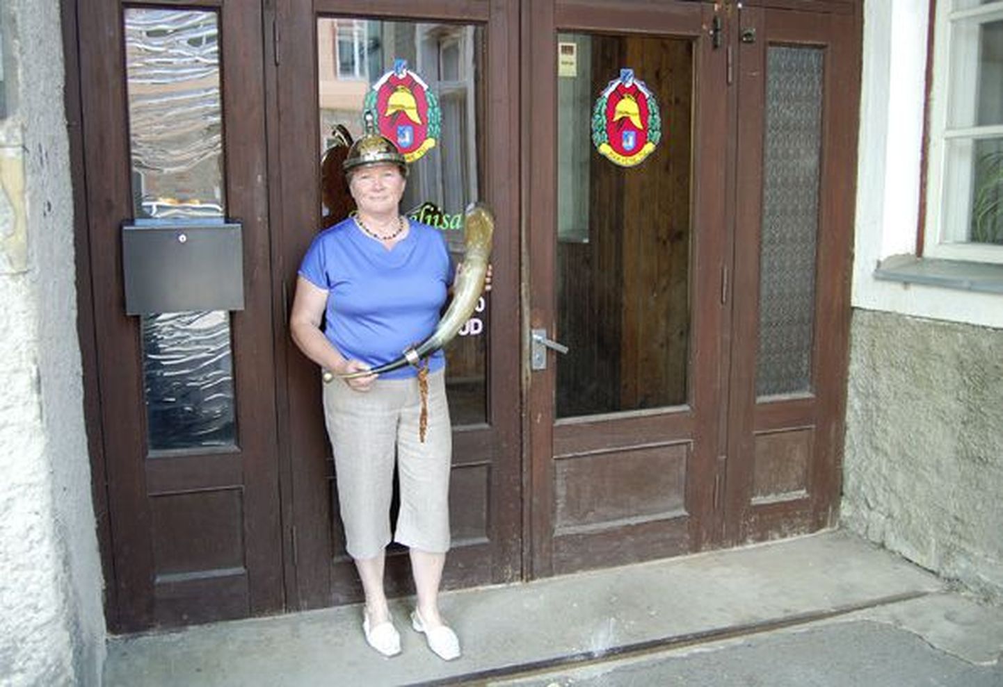 Kingiks saadud sarve ja tuletõrjepealiku uhket kiivrit näitav Mari Rajasalu ootab huvilisi sel reedel sisse astuma tuletõrjeühingu uksest Rakveres Pikk tn 51.