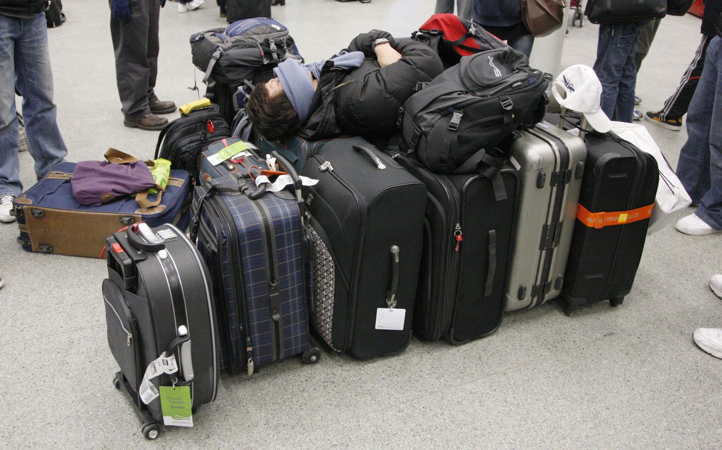 Reisija puhkab oma kohvrite peal