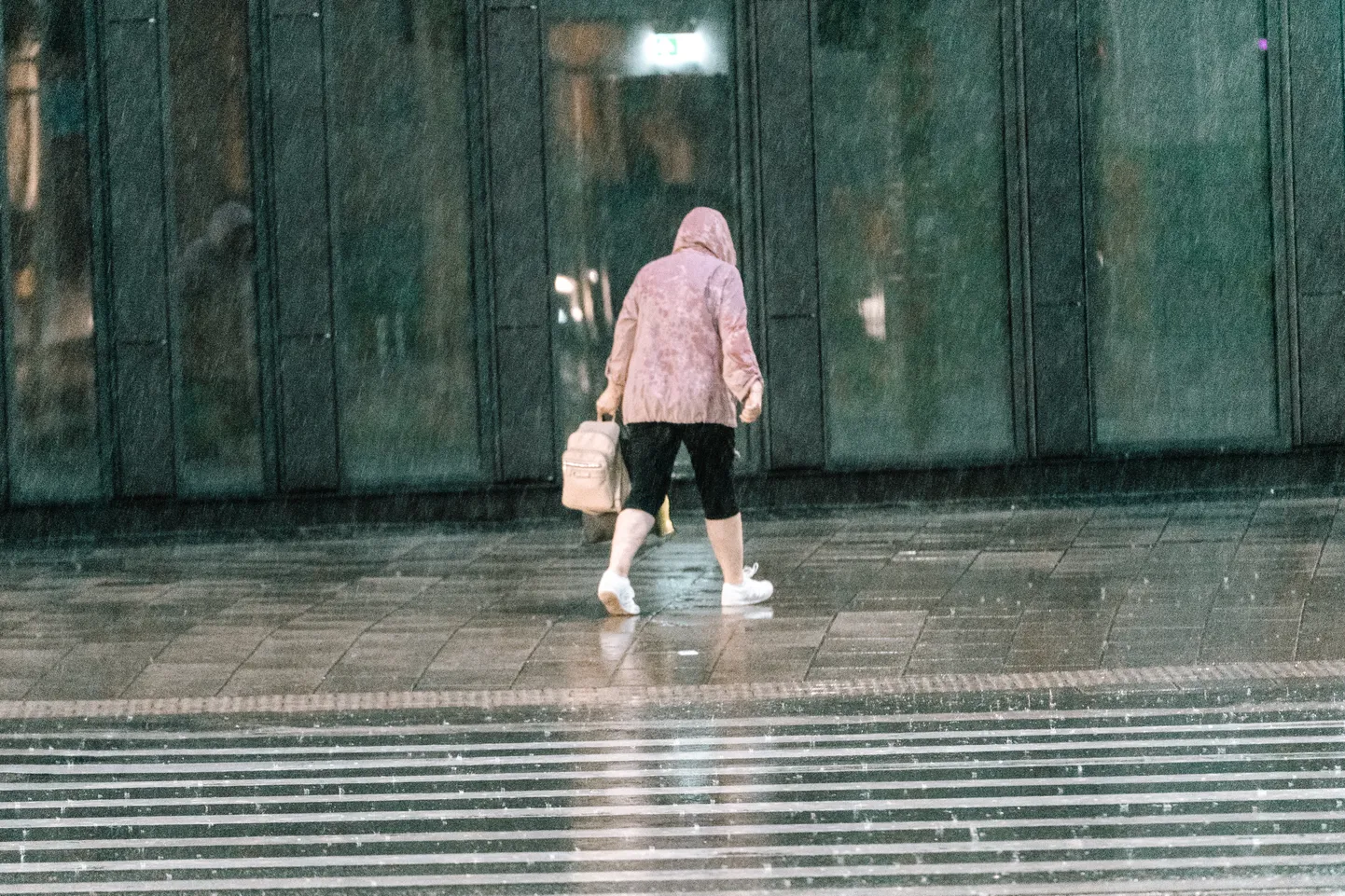 Cilvēki Rīgā cenšas patverties no nopietnas lietusgāzes