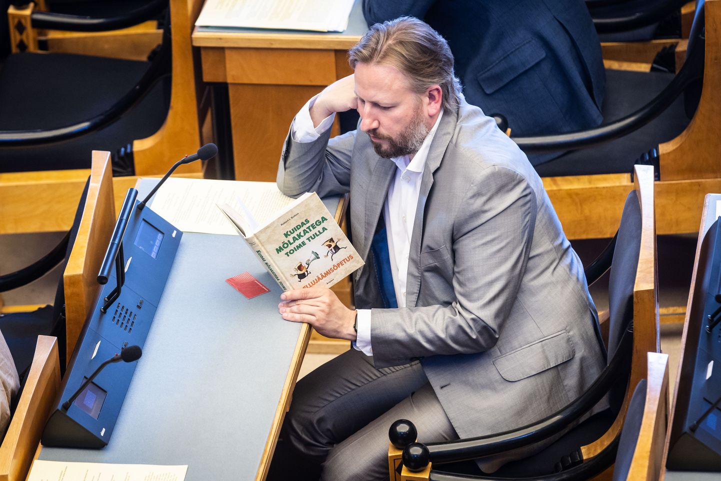 Депутат Рийгикогу Марио Кадастик читает в зале заседаний книгу. 15 мая 2023 года.