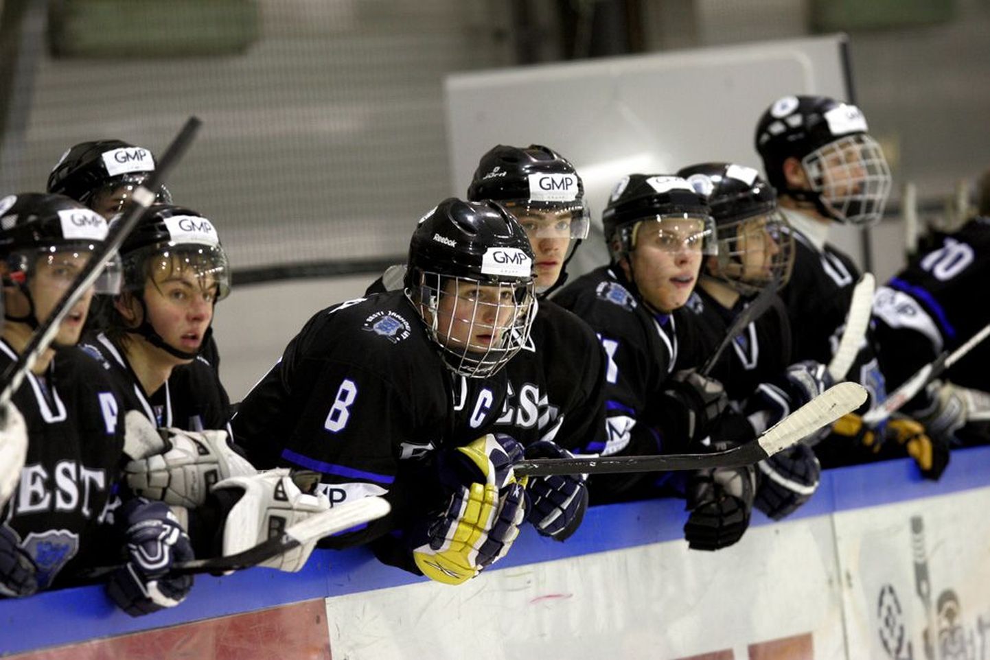 Eesti U20 koondise vahetusmängijate pingil istuvad liikmed jälgivad platsil toimuvat. Alla 18-aastased mängijad tunneb ära näo ees kantava kaitsevõre järgi.