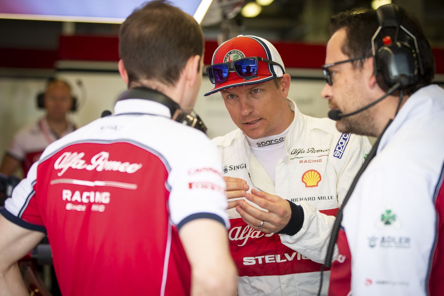 Kimi Räikkönen (keskel) arutab meeskonnaga asju.