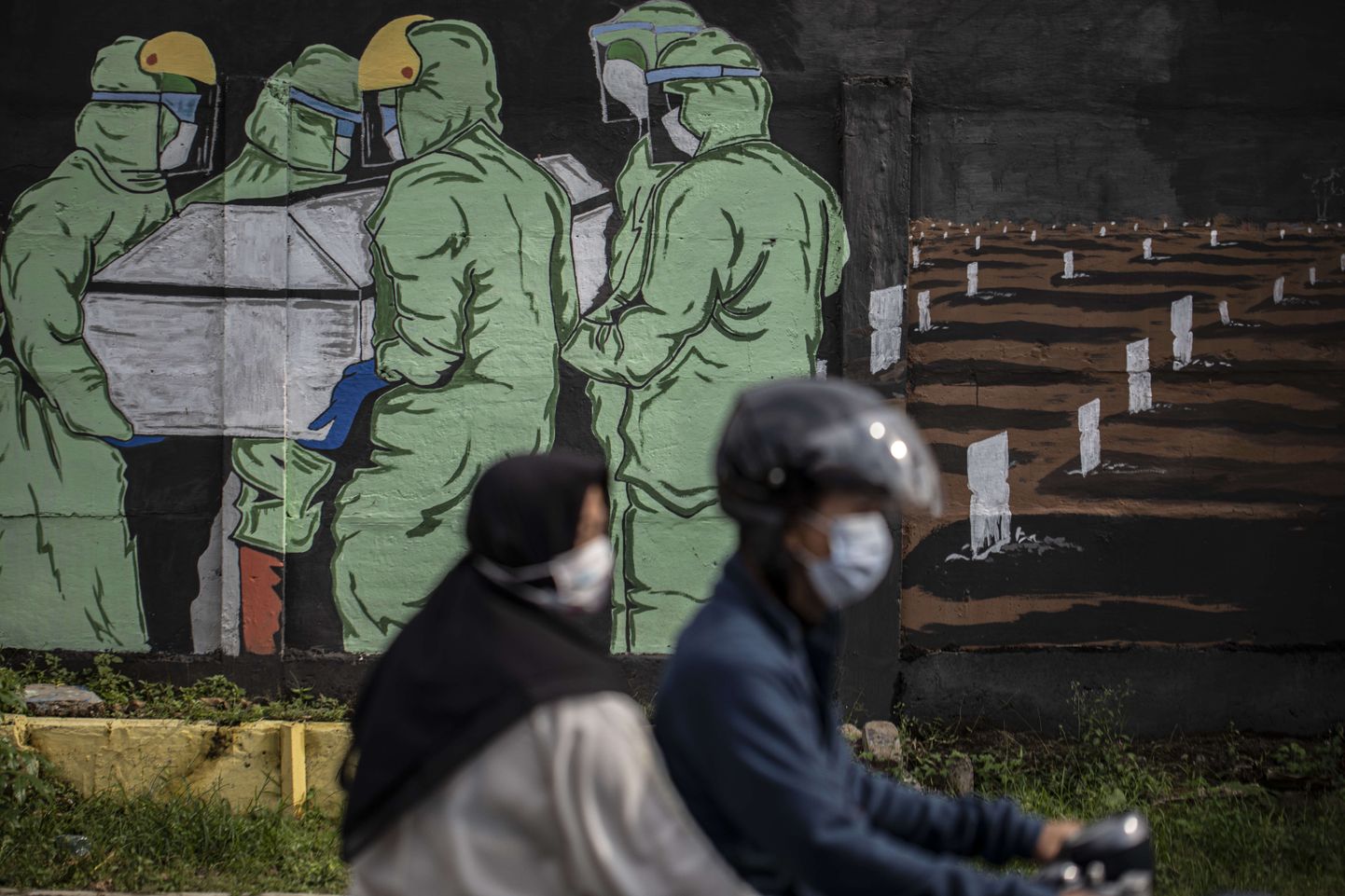 Inimesed möödumas koroonateemalisest seinamaalingust Jakartas.