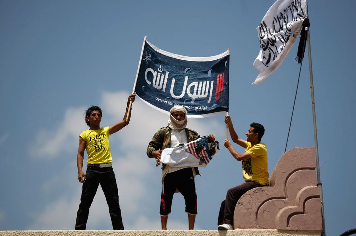 Moslemitest meeleavaldajad Jeemeni pealinnas Sanaas asuva USA saatkonna juures rebimas puruks Ühendriikide lippu. Plakatil aga nõutakse moslemitelt prohvet Muhamedi kaitsmist.