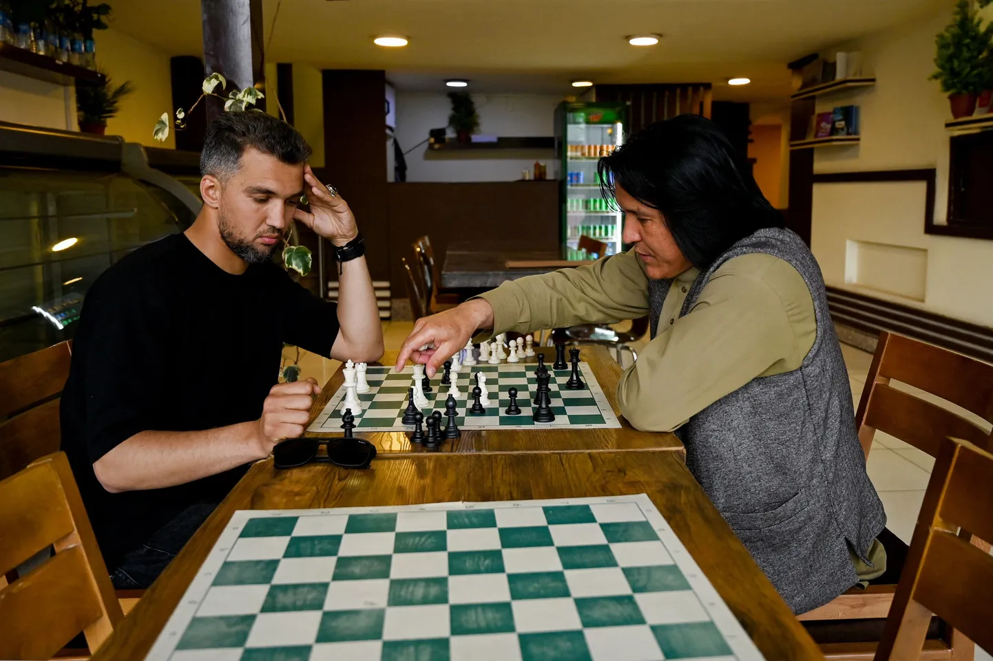 Kohvikuomanik Azizullah Gulzada (paremal) mängib sõbraga malet.