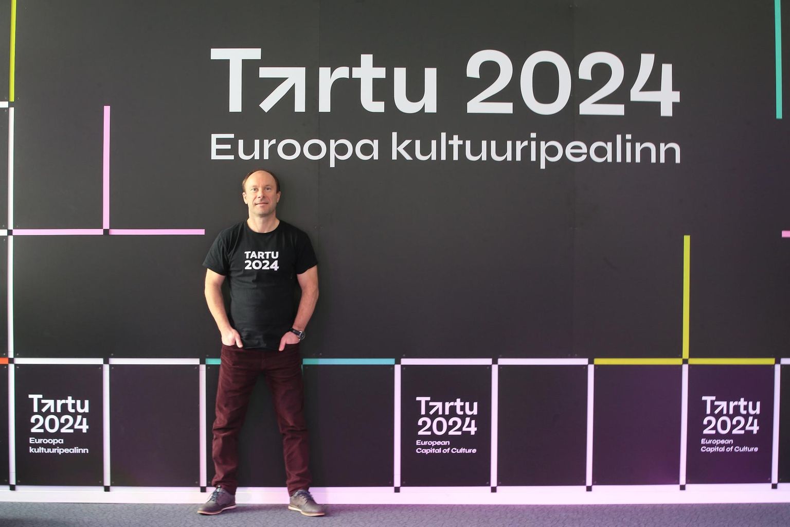Kuldar Leisi selja taga endise stomatoloogiakliiniku suurima saali otsaseinal on Tartu 2024 uus graafiline kujundus, mille on teinud loovagentuur Nope Creative.