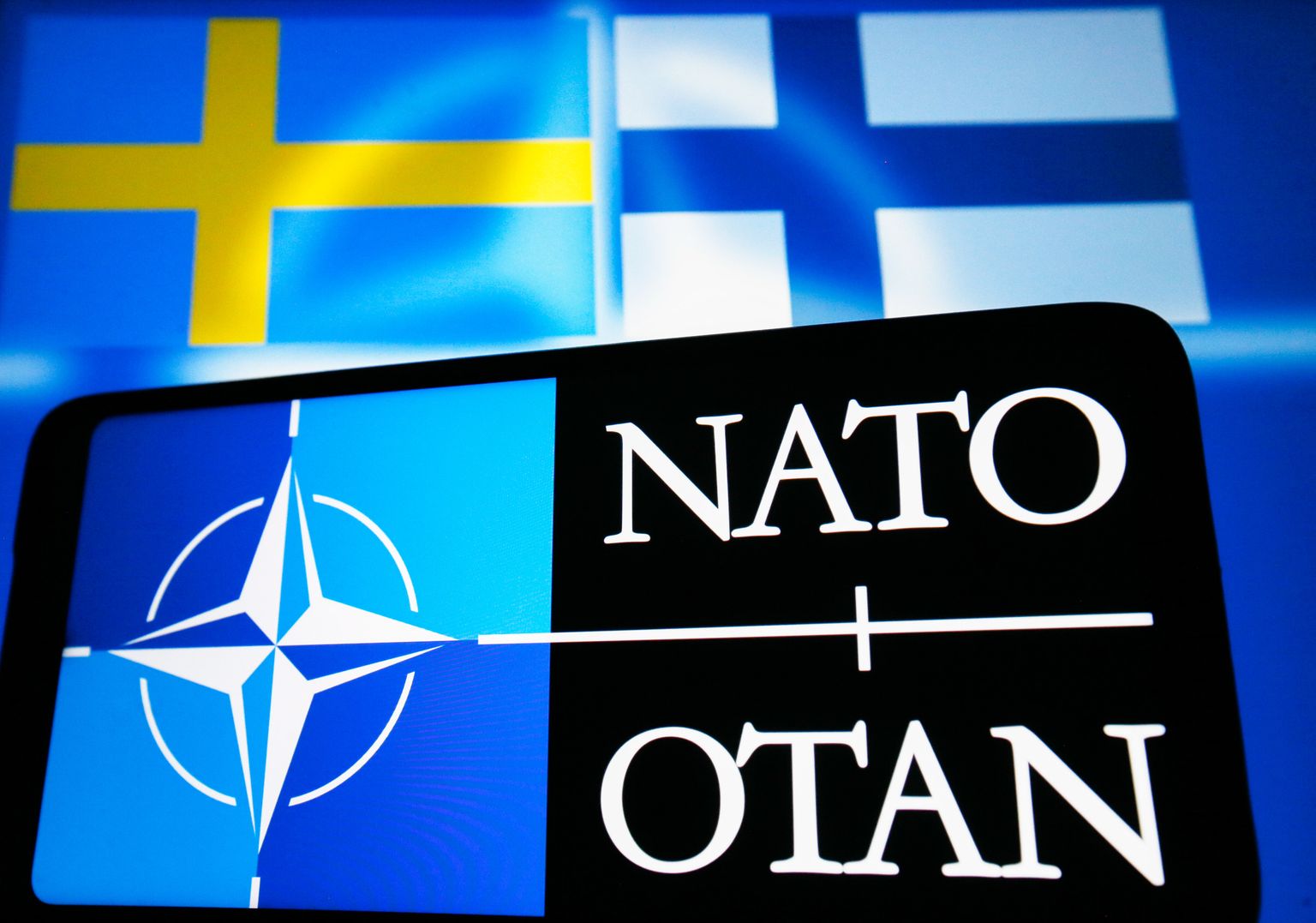 NATO logo koos Soome ja Rootsi lipuga.