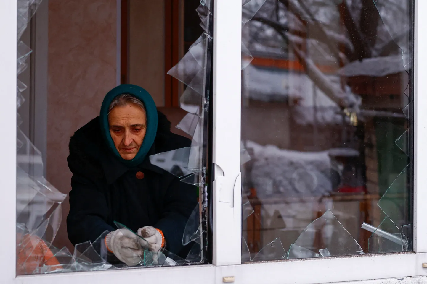 Жительница Киева убирает осколки стекла после ракетной атаки. 11 декабря 2023 года
