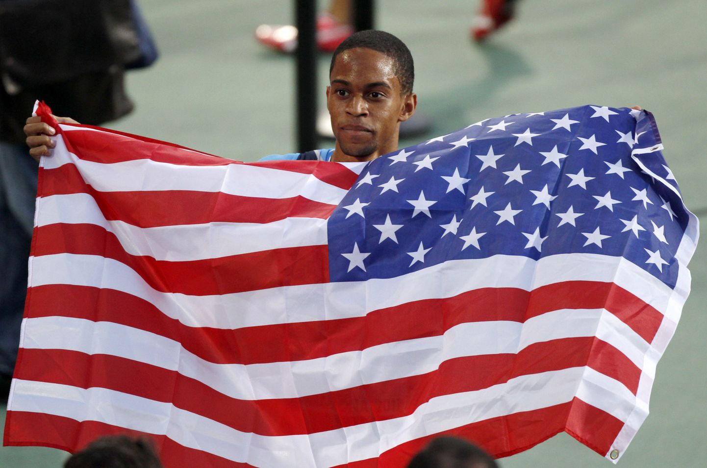 Американский атлет Арман Холл с флагом США.