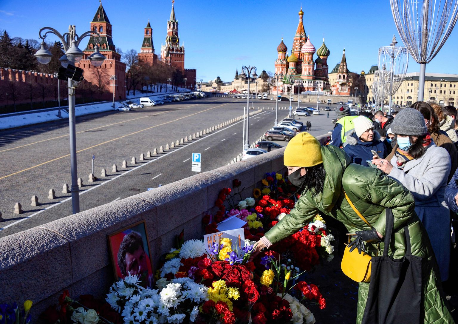 C раннего утра возлагают цветы у народного мемориала на месте гибели российского оппозиционного политика Бориса Немцова, застреленного семь лет назад.