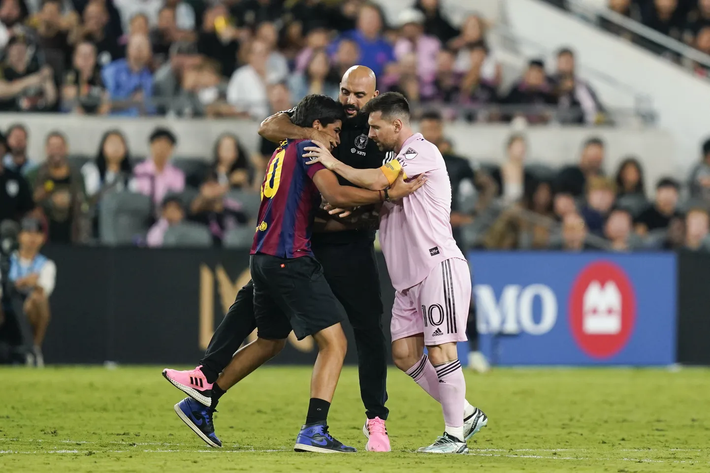 Yassine Cheuko (keskel) eemaldamas väljakule tunginud fänni (vasakul) Lionel Messi küljest.