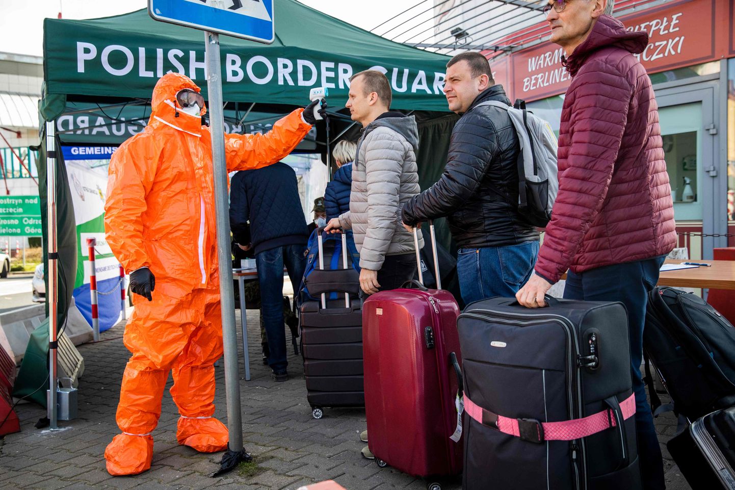 Poola tervishoiutöötaja kontrollimas reisijaid Poola-Saksamaa piiril.