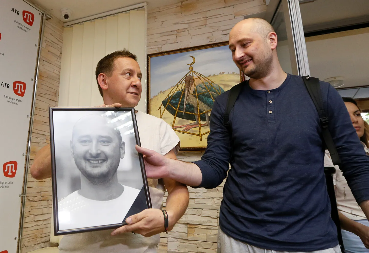 Аркадий Бабченко берет свой траурный портрет у заместителя руководителя крымскотатарского канала ATR, бывшего журналиста российского пропагандистского издания "Московский комсомолец" Айдера Муждабаева, Киев, май 2018 года. Незадолго до этого Бабченко стал участником операции СБУ, в рамках которой россиянин якобы был убит. Это объяснялось разоблачением наемников Кремля в Украине.