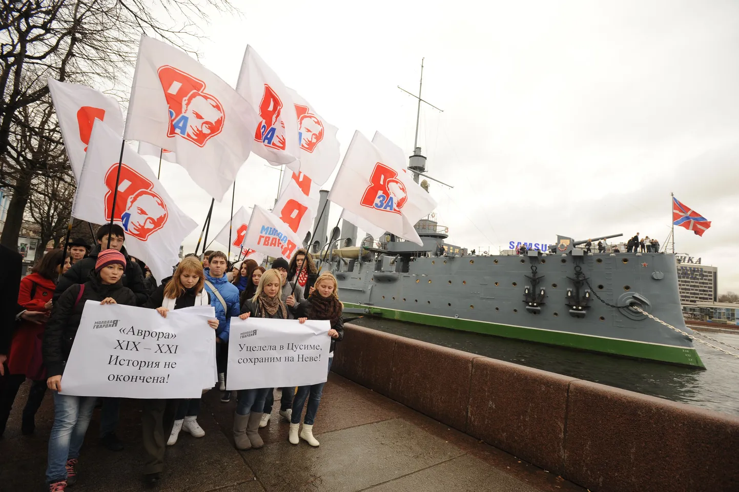 Ristleja Aurora Peterburis Neeva jõel (taga). Esiplaanil Noore Kaardväe aktivistid, kes protesteerivad Aurora meeskonna laiali saatmise vastu.