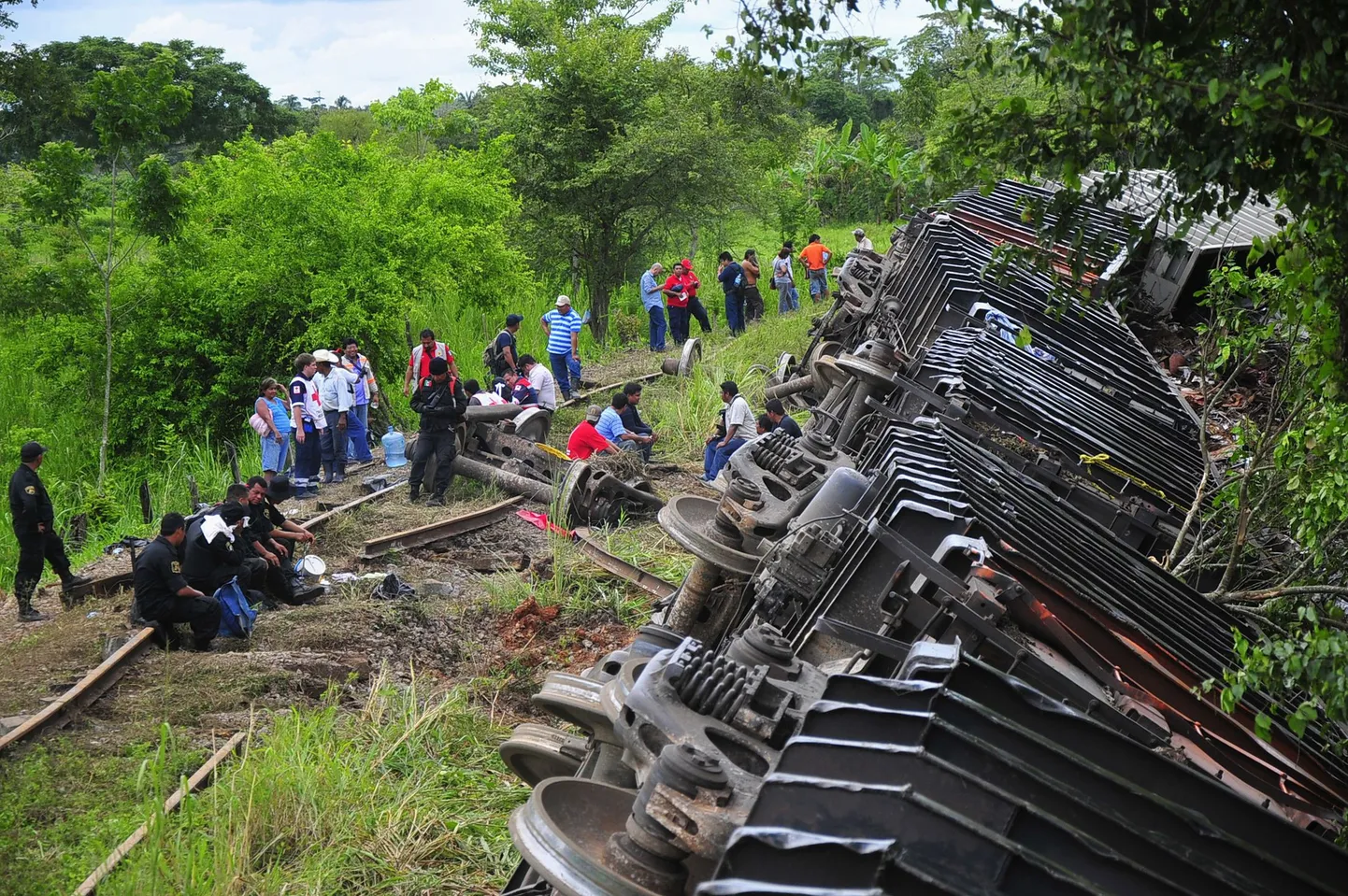 Politseinikud ja päästetöötajad Tabasco osariigis rööbastelt välja sõitnud rongi kõrval.