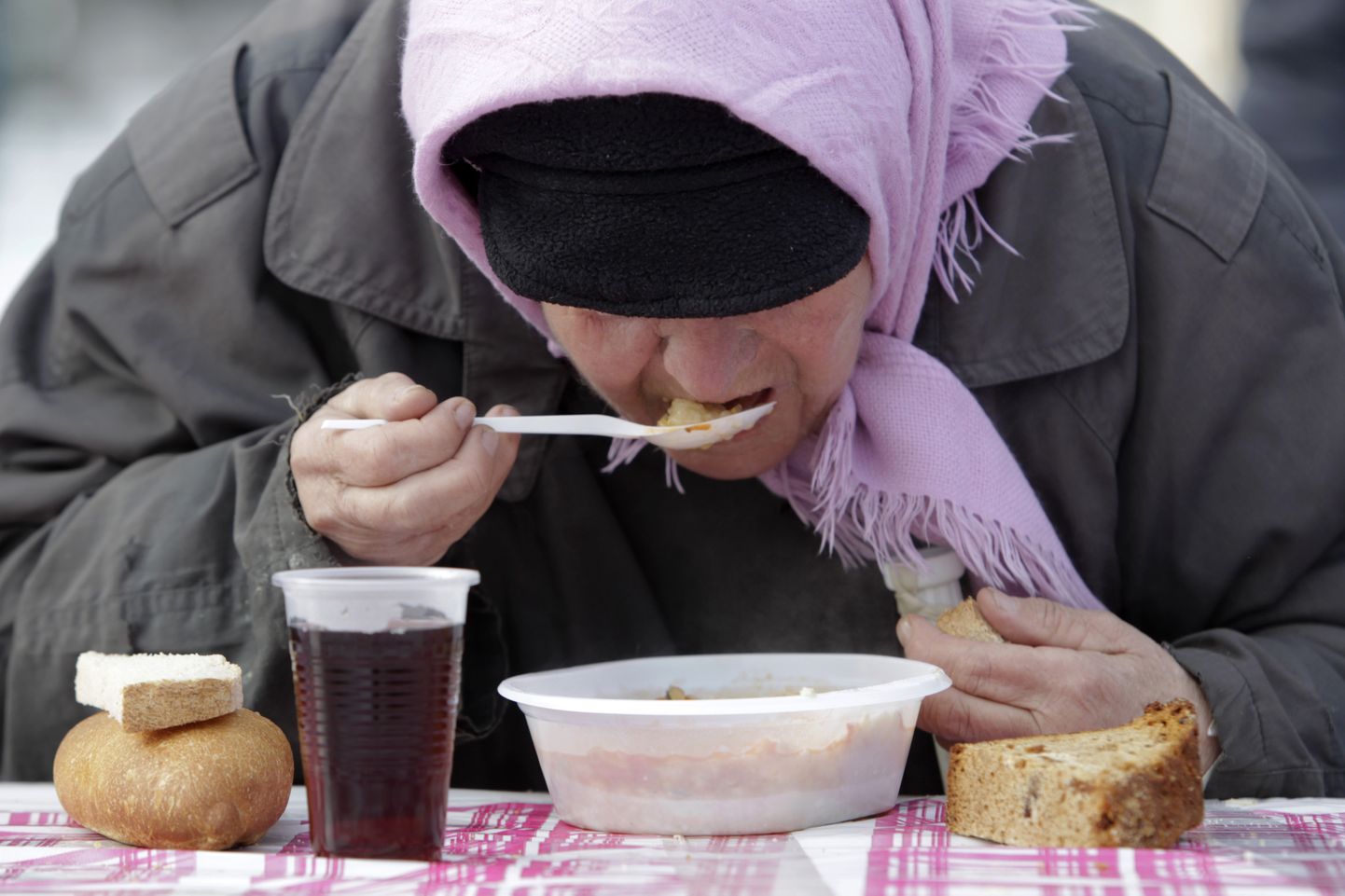 Eakas naine söömas heategevusüritusel Stavropolis.