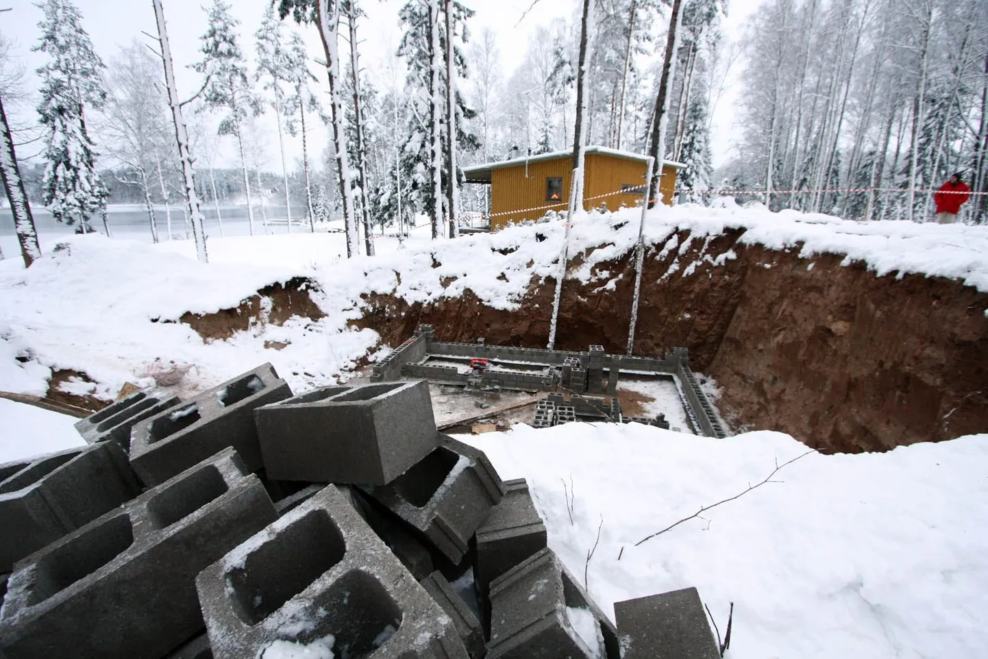 Tagantpoolt paistva kollase maja omanikule Verni Loodmaale tuli ootamatusena, et tema kinnistu külje alla kerkib väikeehitis, milles koos keldri ja katusealuse korrusega kokku pea 150 ruutmeetrit kasutatavat pinda. Puude vahelt paistab Inni järv.