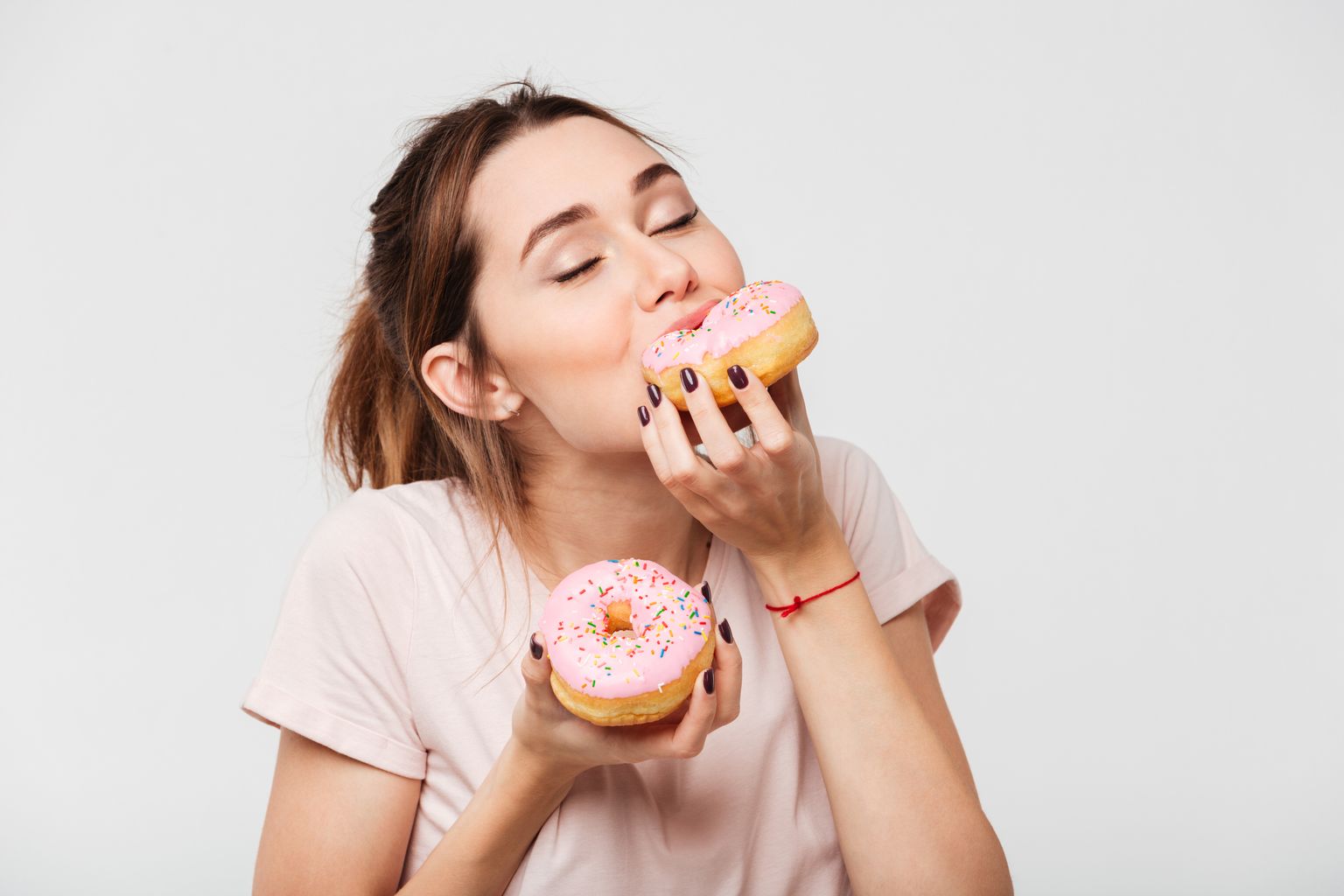 Женщина ест пончик. Иллюстративное фото