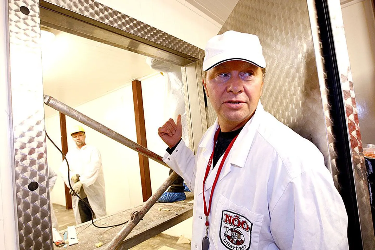 Nõo lihatööstuse tegevjuht Toomas Kruustük osutab kohale laoruumi laes, kuhu ehitajad tegid eile ennelõunal auku betoonpostile, mis seob kokku praeguse ja tulevase hoone.