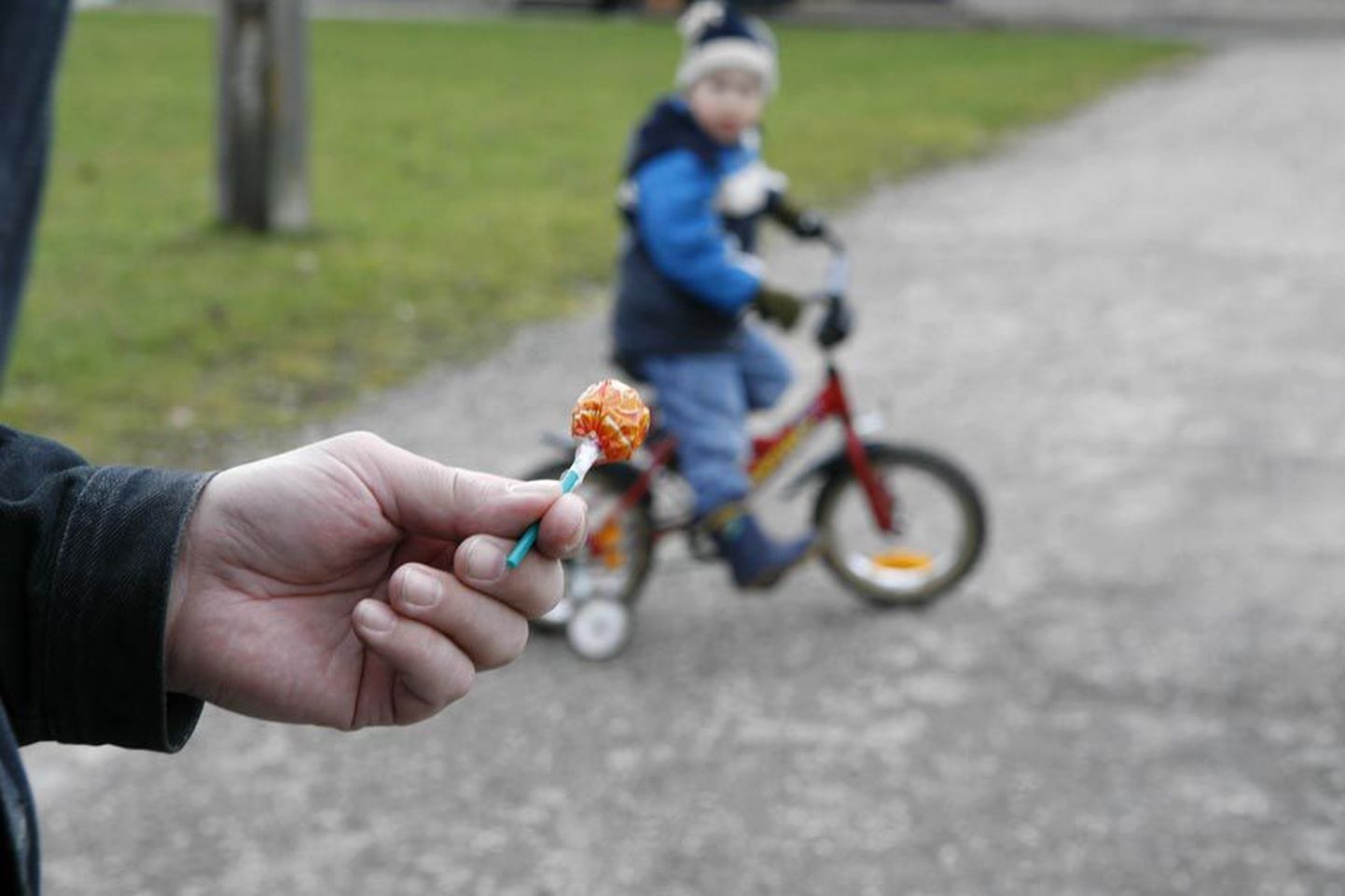 Взрослый предлагает ребенку конфету. Фото иллюстративное.