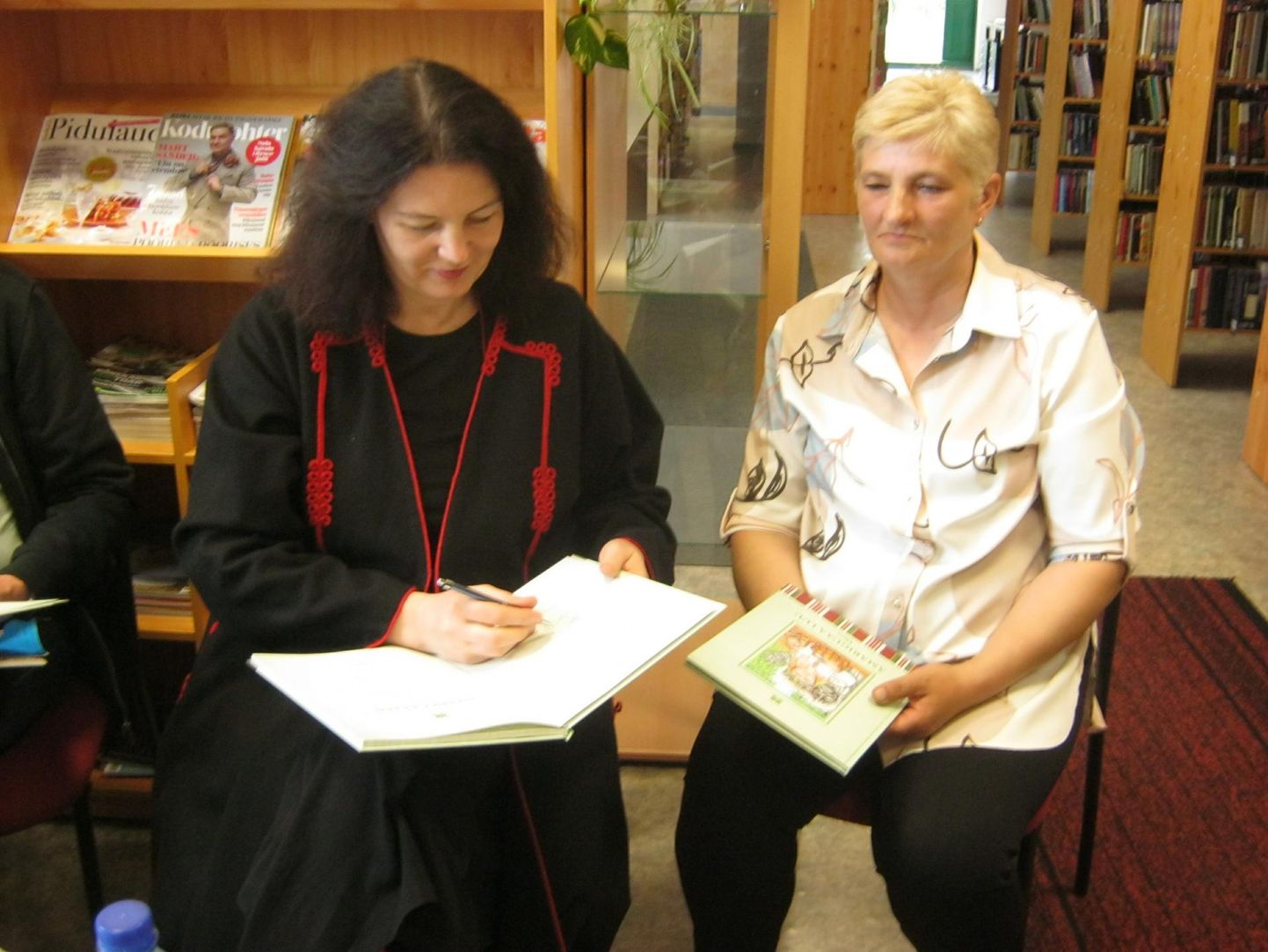 Raamatu «Ämäriguaa luu. Elme» koostaja Kristi Ilves (vasakul) ja kunstnik Ülle Rosenberg jagasid Tõrva raamatukogus teose esitlemisel autogramme.